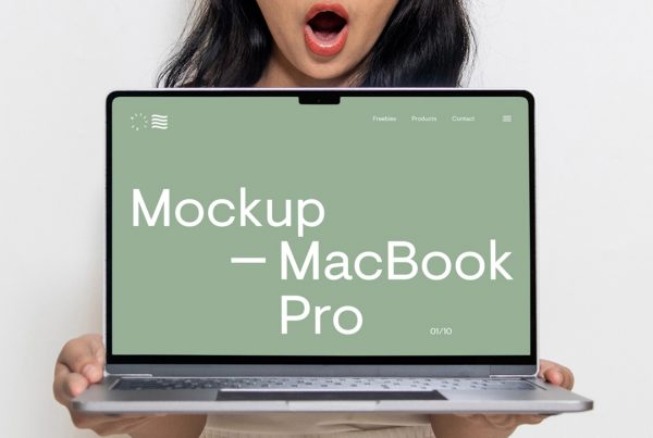 Free front view, Free MacBook Pro Mockup held in the hands of a woman with green hero page design against white wall in the background.