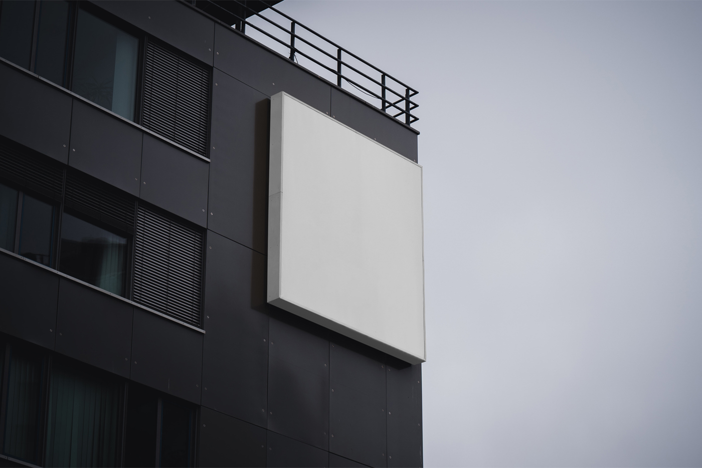 Bottom view, White Free Sign on Building Mockup is attached to the black building facade on the top.