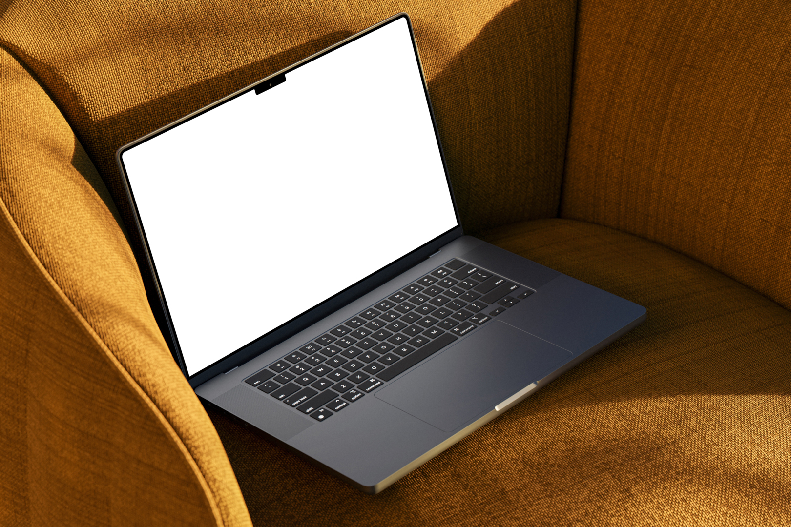 Seen from above, space gray blank MacBook Pro Mockup laying on the reddish yellow couch.