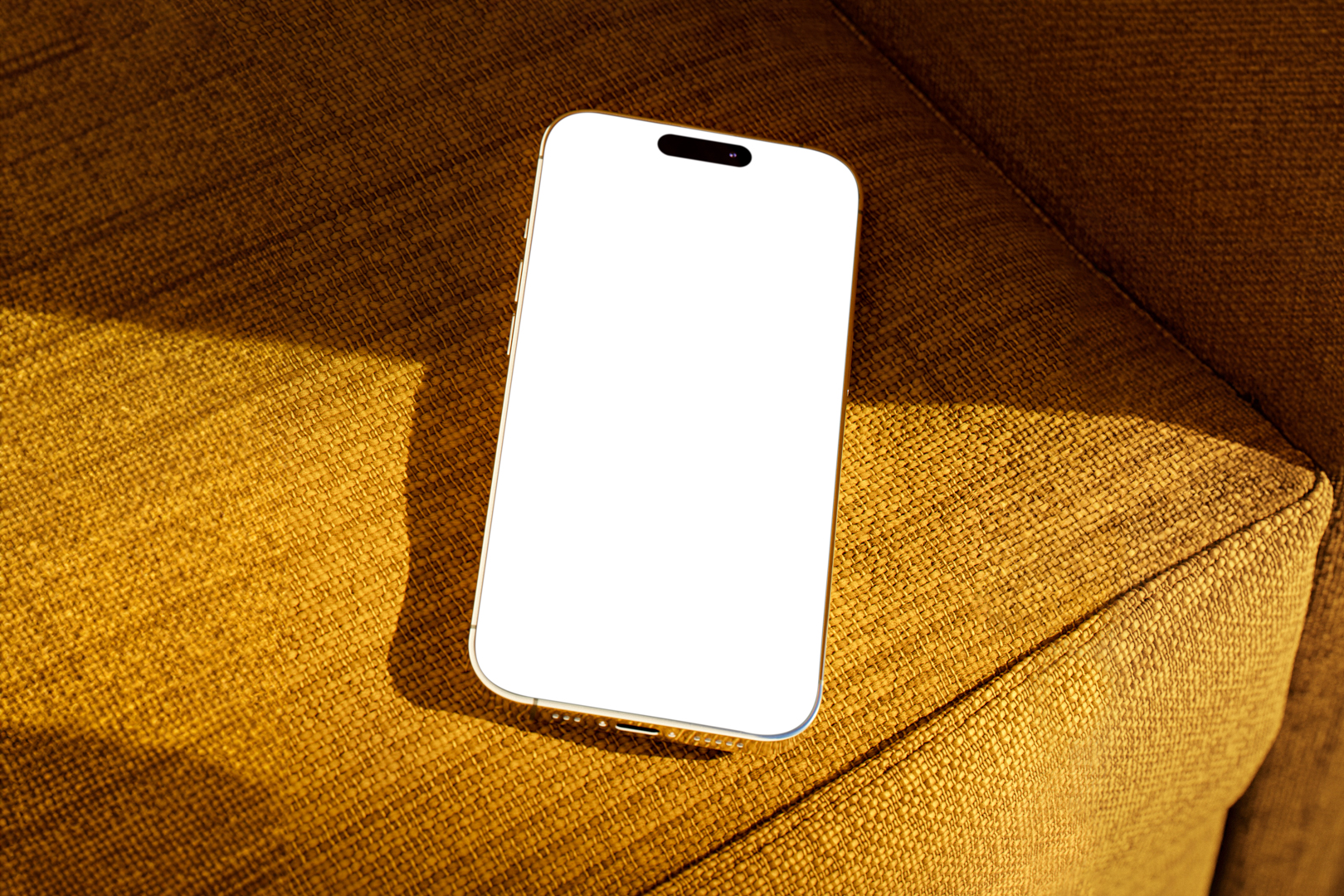 Seen from above, gold blank iPhone 14 Pro Mockup laying on the reddish yellow couch.