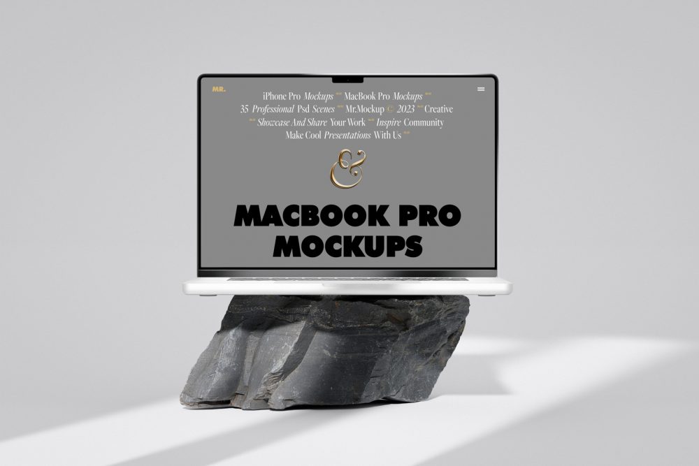 Front view, MacBook Pro Mockup with gray design standing on the big rock against a bright gray background.