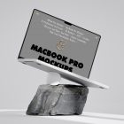 Front view, MacBook Pro Mockup with gray design standing on the white apple mouse and piece of rock against bright gray floor and wall.