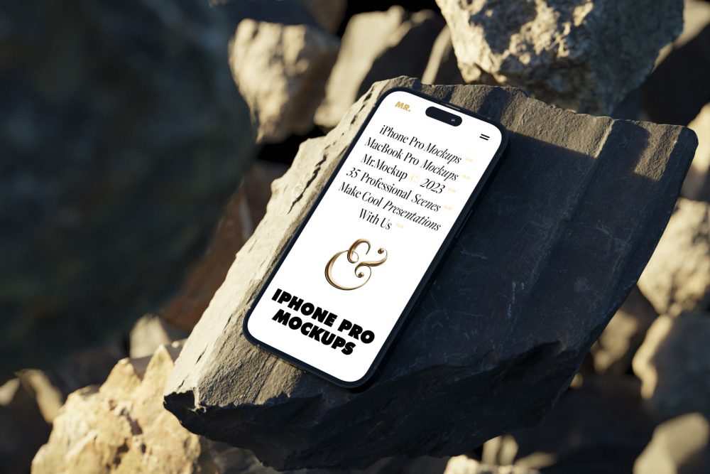 Seen from above, iPhone 14 Pro Mockup with white design laying on the sunny rocks on the beach against water in the background.