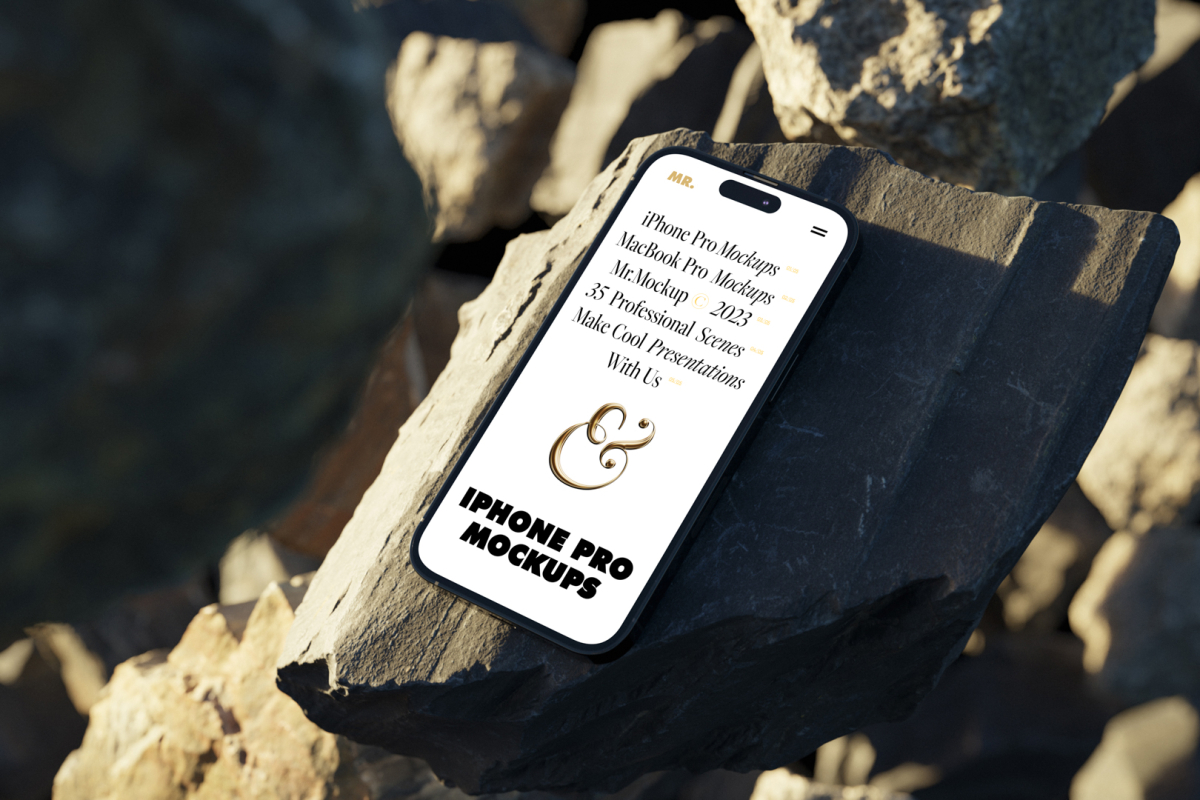 Seen from above, iPhone 14 Pro Mockup with white design laying on the sunny rocks on the beach against water in the background.