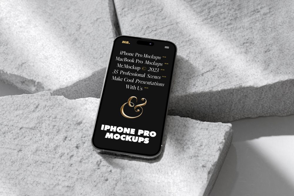 Seen from above, iPhone 14 Pro Mockup with black design laying on the pieces of a styrofoam laying on the white floor.