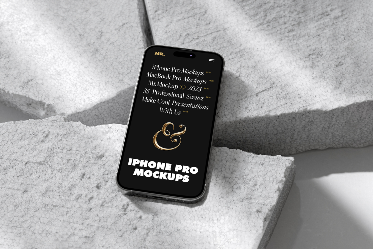 Seen from above, iPhone 14 Pro Mockup with black design laying on the pieces of a styrofoam laying on the white floor.