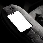 Blank iPhone 14 Pro Mockup, seen from above, laying on the dark gray couch.