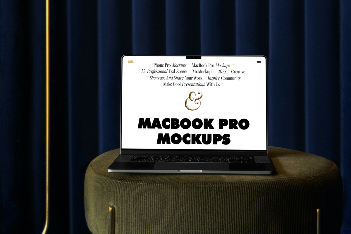 Front view MacBook Pro Mockups with white design laying on the bottle green pouf with gold elements against a deep blue curtain in the background.