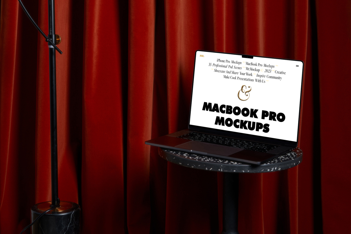 Front view, MacBook Pro Mockup with white design standing on the marble chair against a deep red curtain in the background.