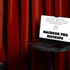 Front view, MacBook Pro Mockup with white design standing on the marble chair against a deep red curtain in the background.