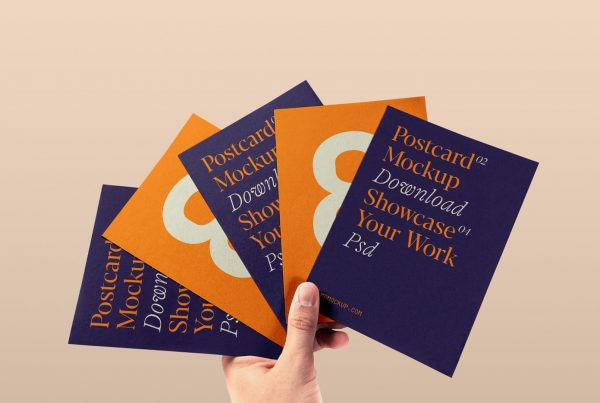 Free four Postcards in Hand Mockup with purple and orange design colors against beige color in the background.