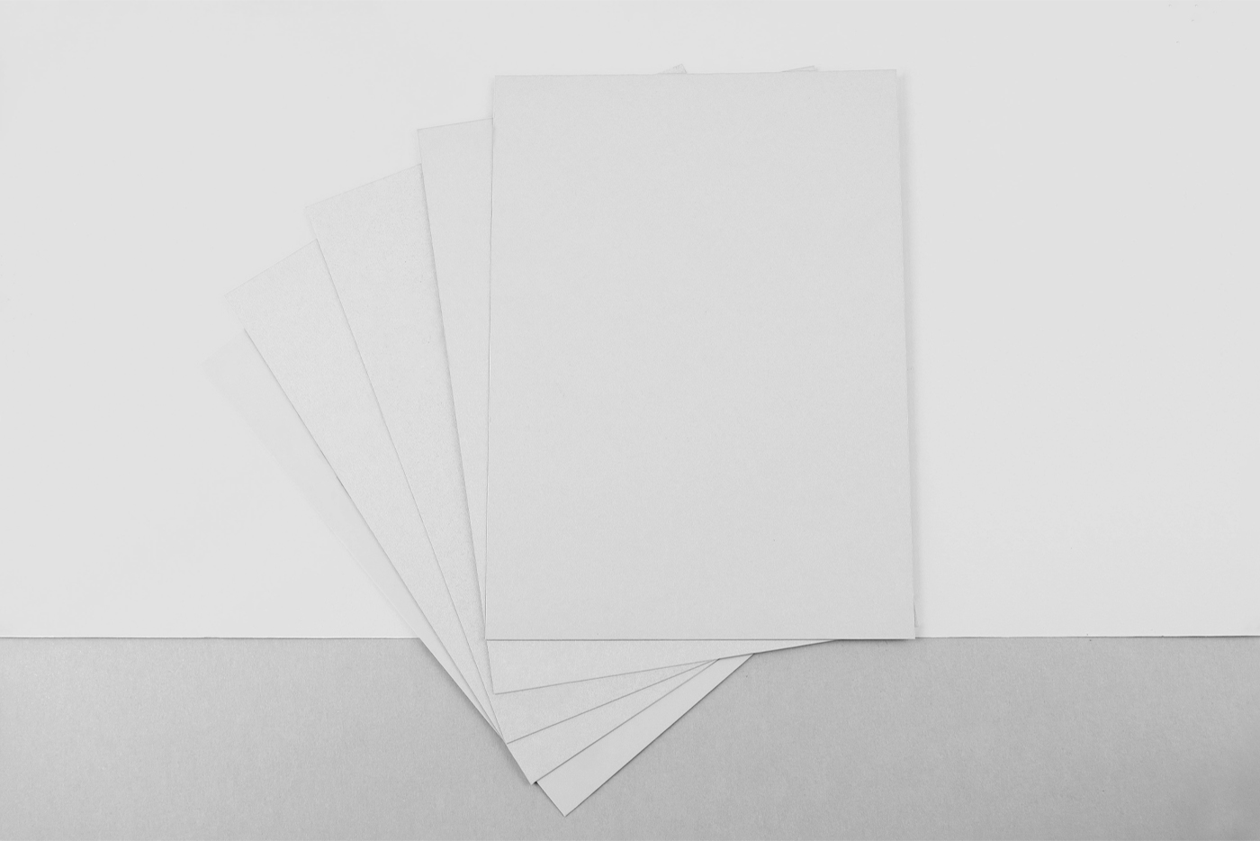 Free four Postcards on Floor Mockup with purple and pink design colors are lying on the beige and pink floor colors.