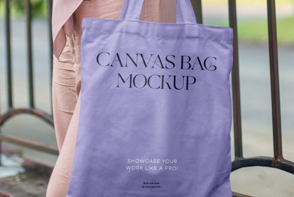 Women holding a purple canvas bag mockup in front of the city park.