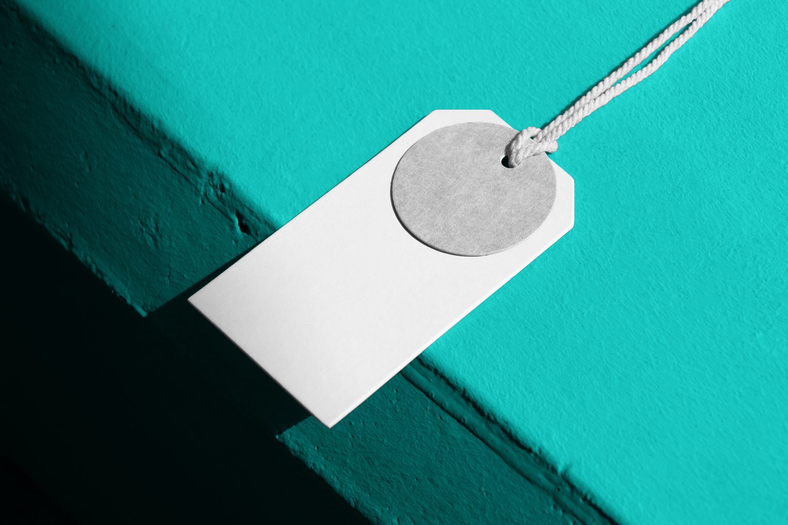 Seen from above, white label mockup laying on the celadon concrete.