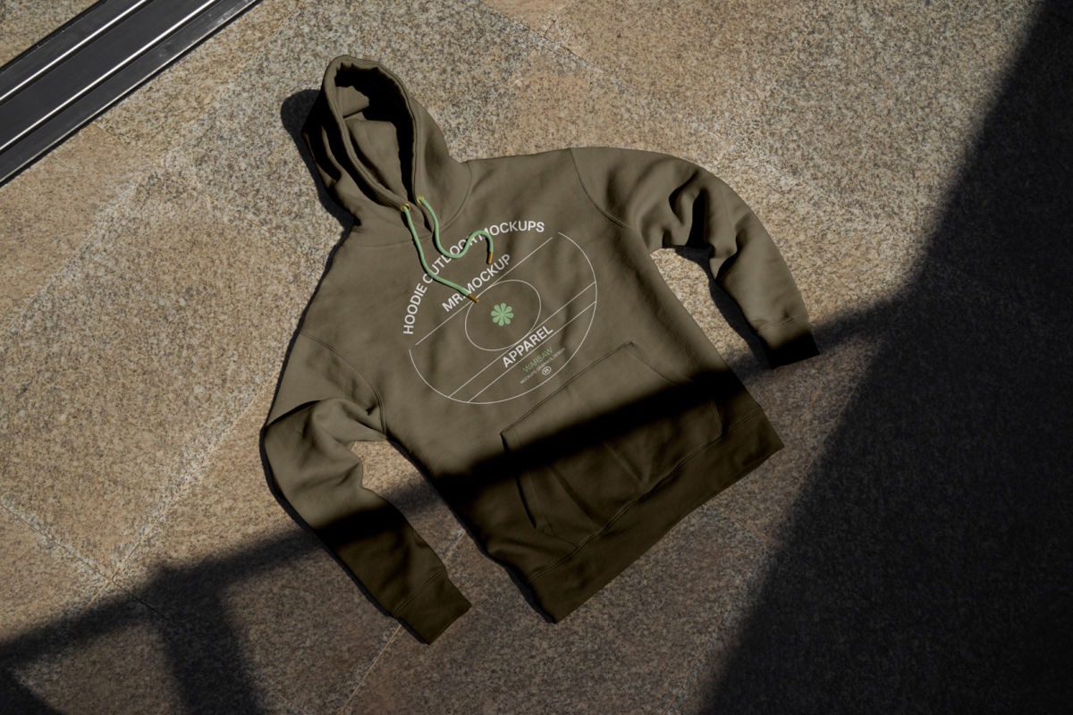 Seen from above, rotten green Hoodie Mockup with bright green strips laying on the ginger marble floor.
