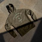 Seen from above, rotten green Hoodie Mockup with bright green strips laying on the ginger marble floor.