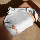 Seen from above, White Hoodie Mockup laying on the creamy bench against on the marble street.