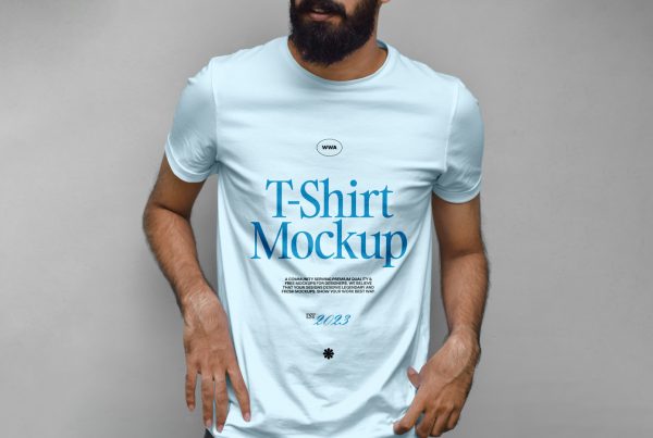 Standing men wearing blue t-shirt with a navy typography design in front of the gray wall.