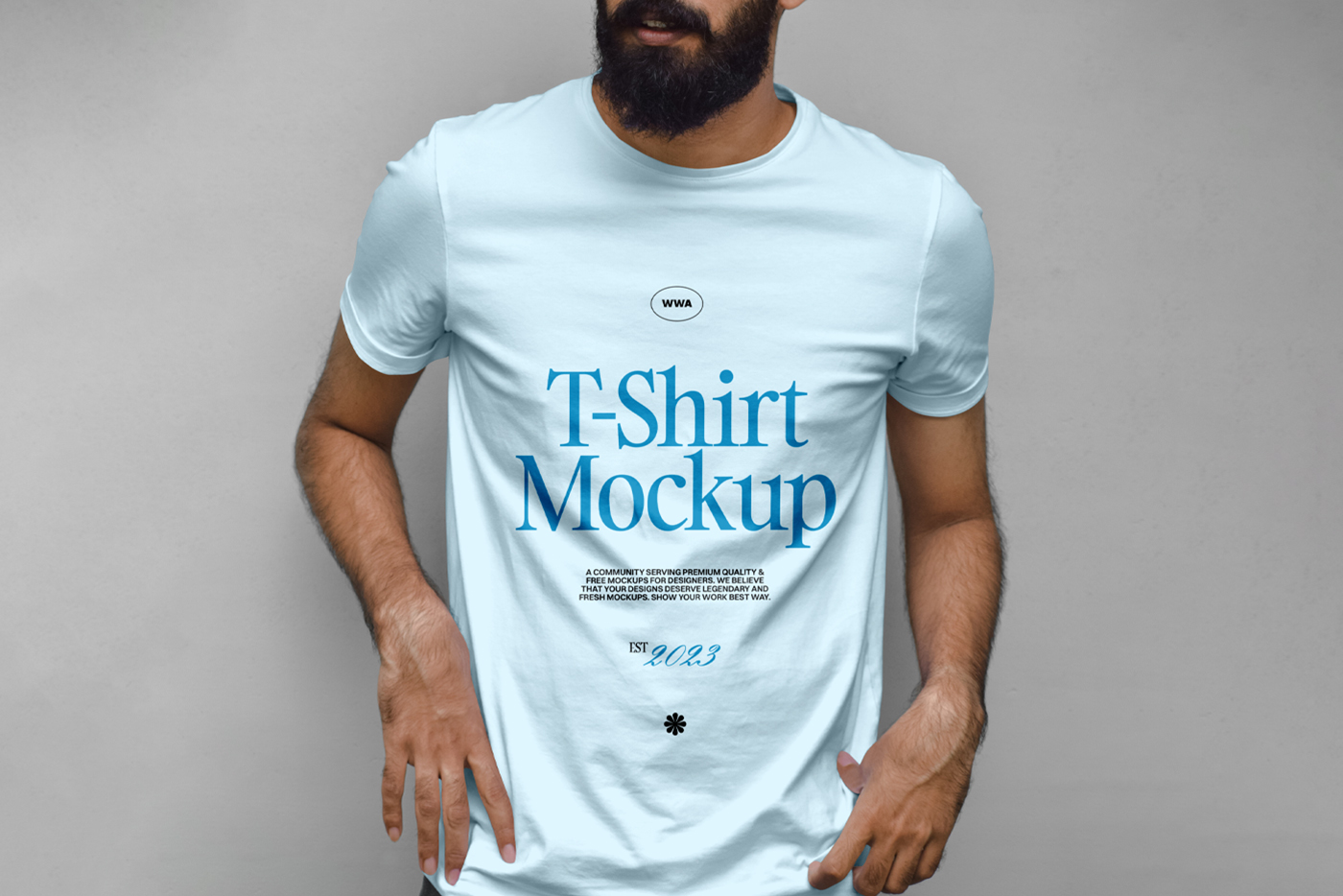Standing men wearing blue t-shirt with a navy typography design in front of the gray wall.