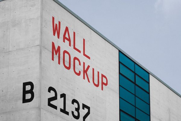 Front view, building facade mockup with strong red typography design and a visible sky behind.