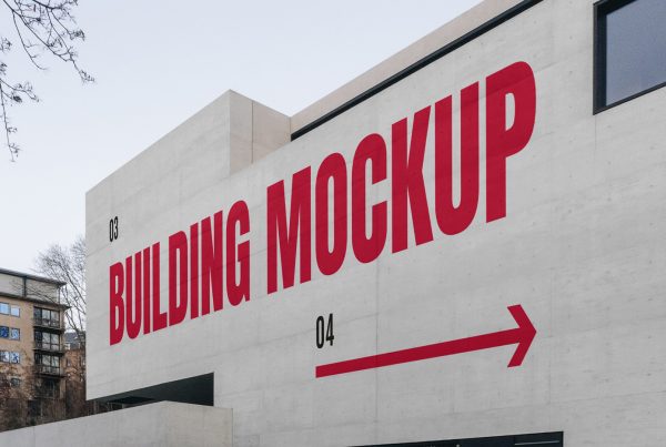 Front view, building wall mockup with strong red typography design and a visible sky behind.