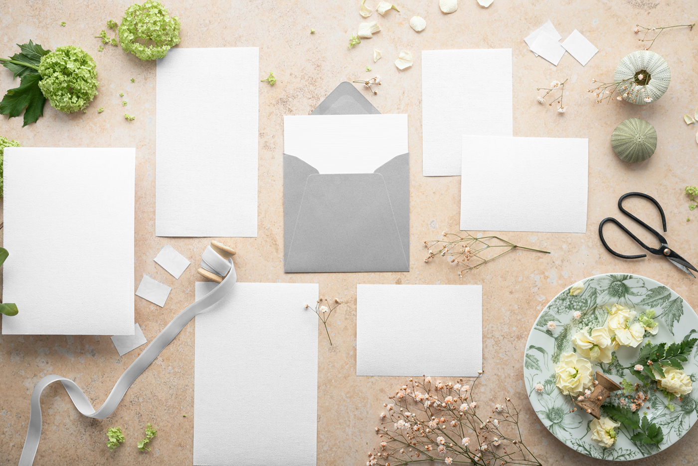 View from above, blank paper stationery set mockup laying on the bright yellow concrete floor.