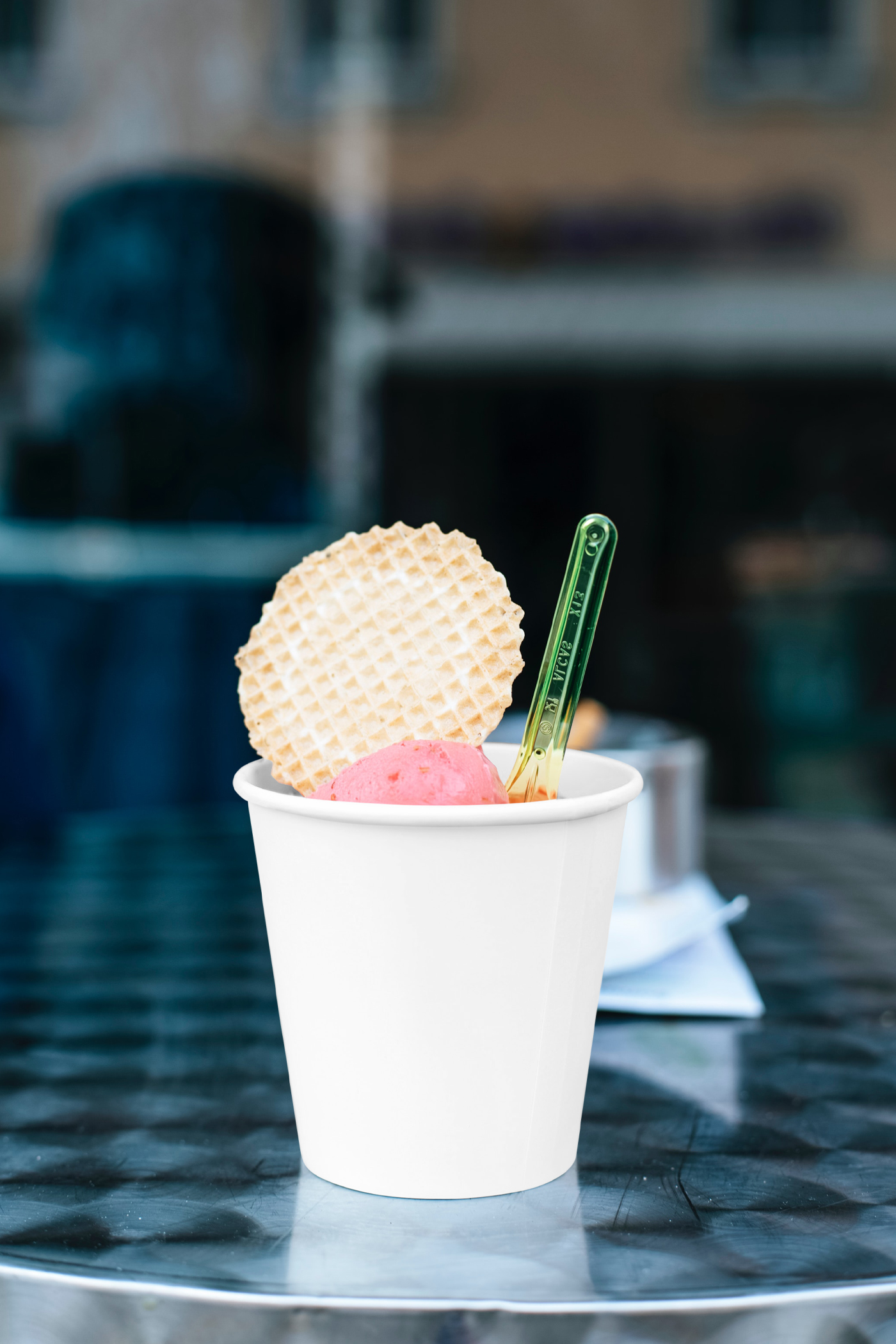 Front view, ice cream blank paper cup mockup standing on the metal table.