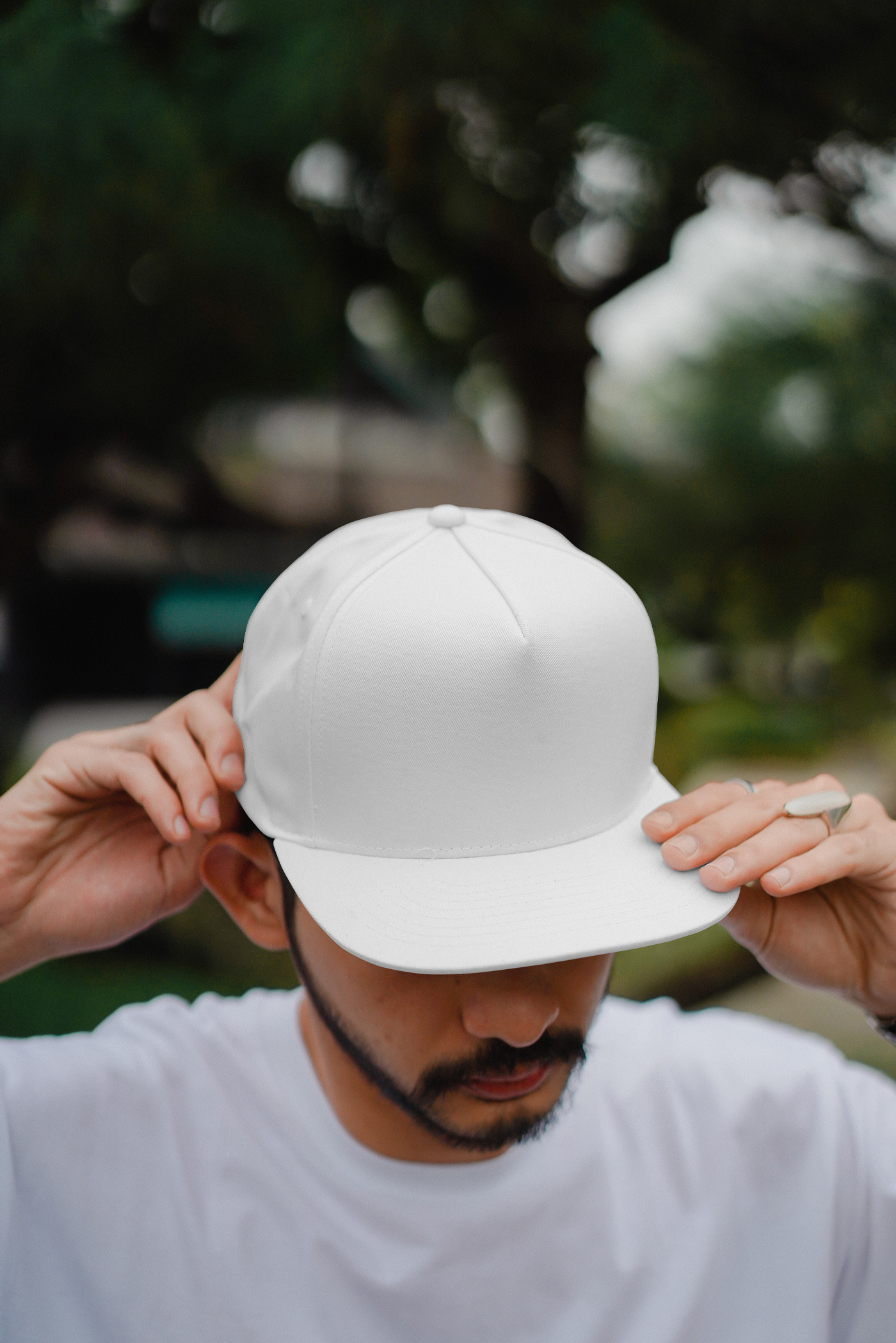 Men wearing blank snap back cup mockup in front of the blurred city nature.