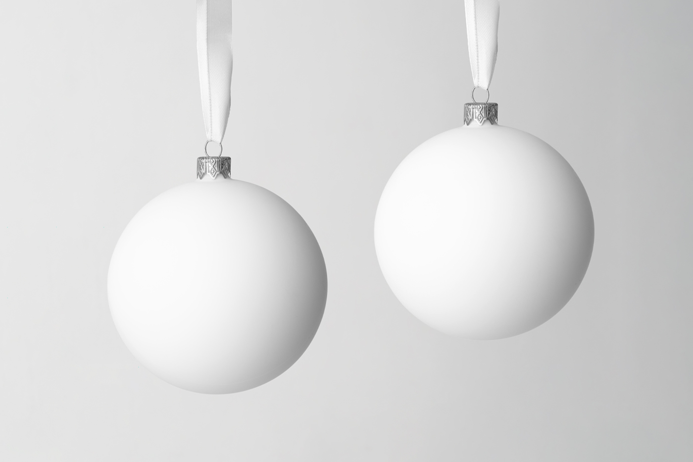 Front view, two blank Christmas Bauble Mockup hanging in front of the gray wall.