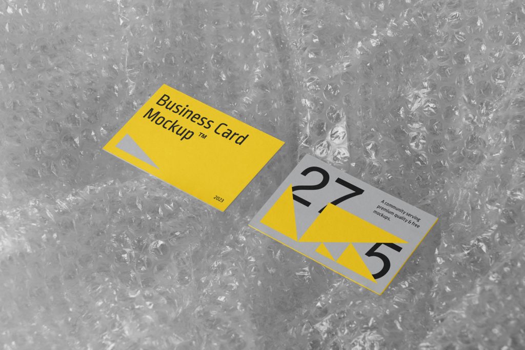 View from above, business card mockup laying on the transparent bauble foil.