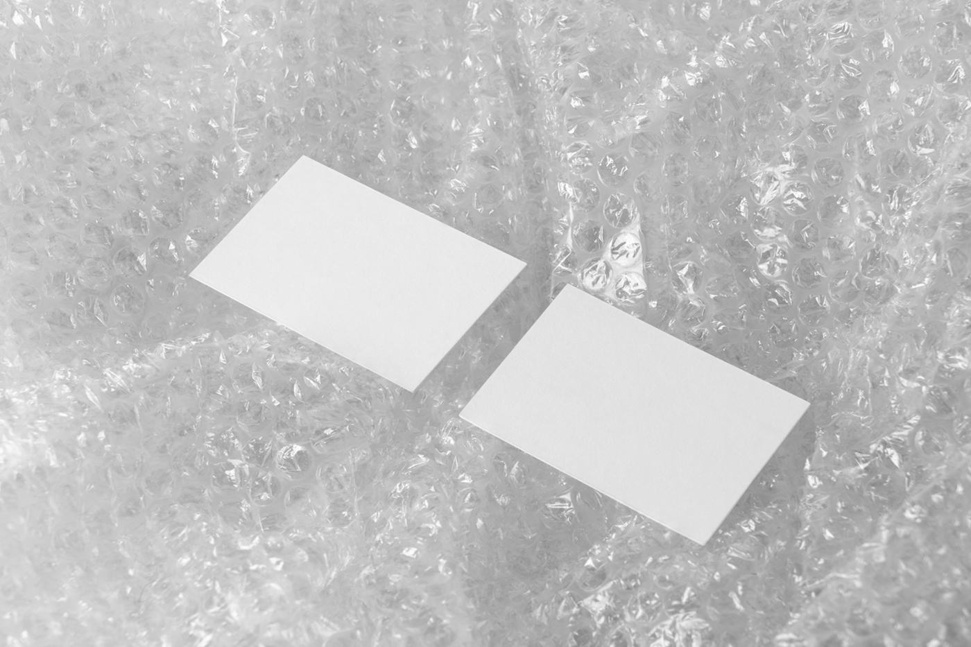 View from above, blank business card mockup laying on the transparent bauble foil.