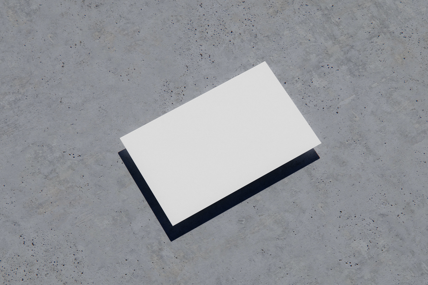 View from above, blank business card mockup laying on the concrete floor.