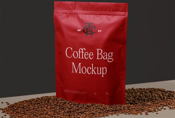 Front view, coffee bag mockup standing among coffee beans and brown box in front of the black wall.