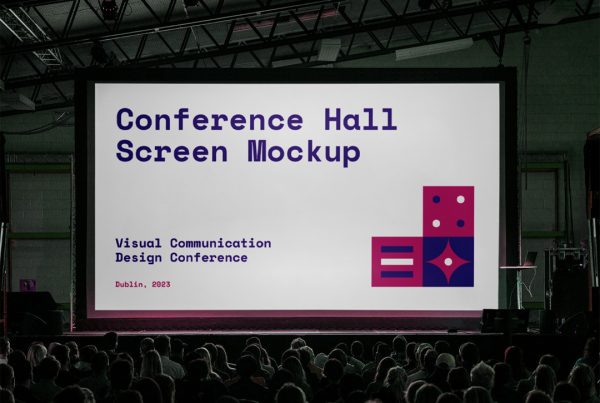 Front view, conference hall screen mockup inside the building with a visible audience.
