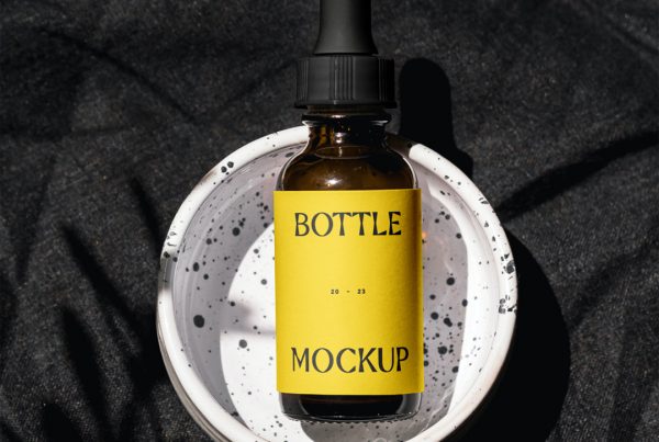 View from above, cosmetic bottle mockup with yellow label laying it's in the terrazzo ashtray.