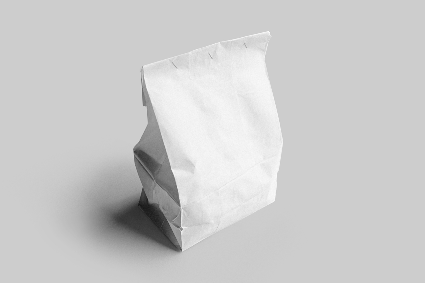 View from above, white paper bag mockup standing on the light gray floor.