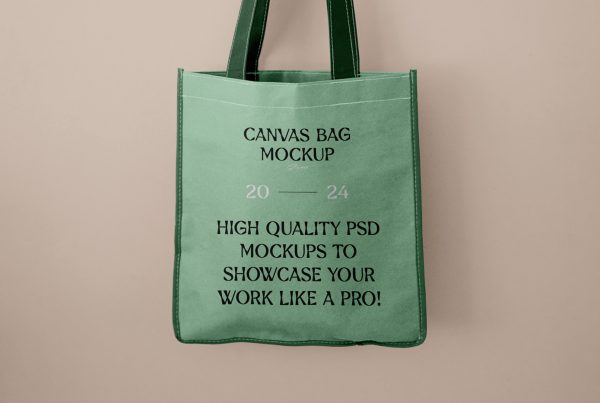 Men holding a green shopping tote bag mockup in front of the beige wall.