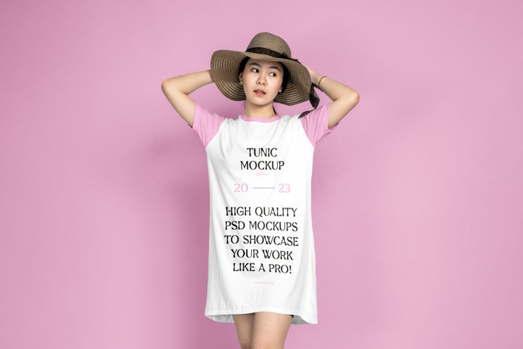 A woman wearing a tunic mockup in front of the pink wall.