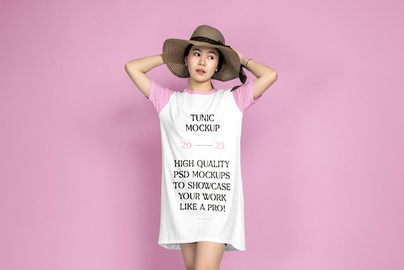 A woman wearing a tunic mockup in front of the pink wall.