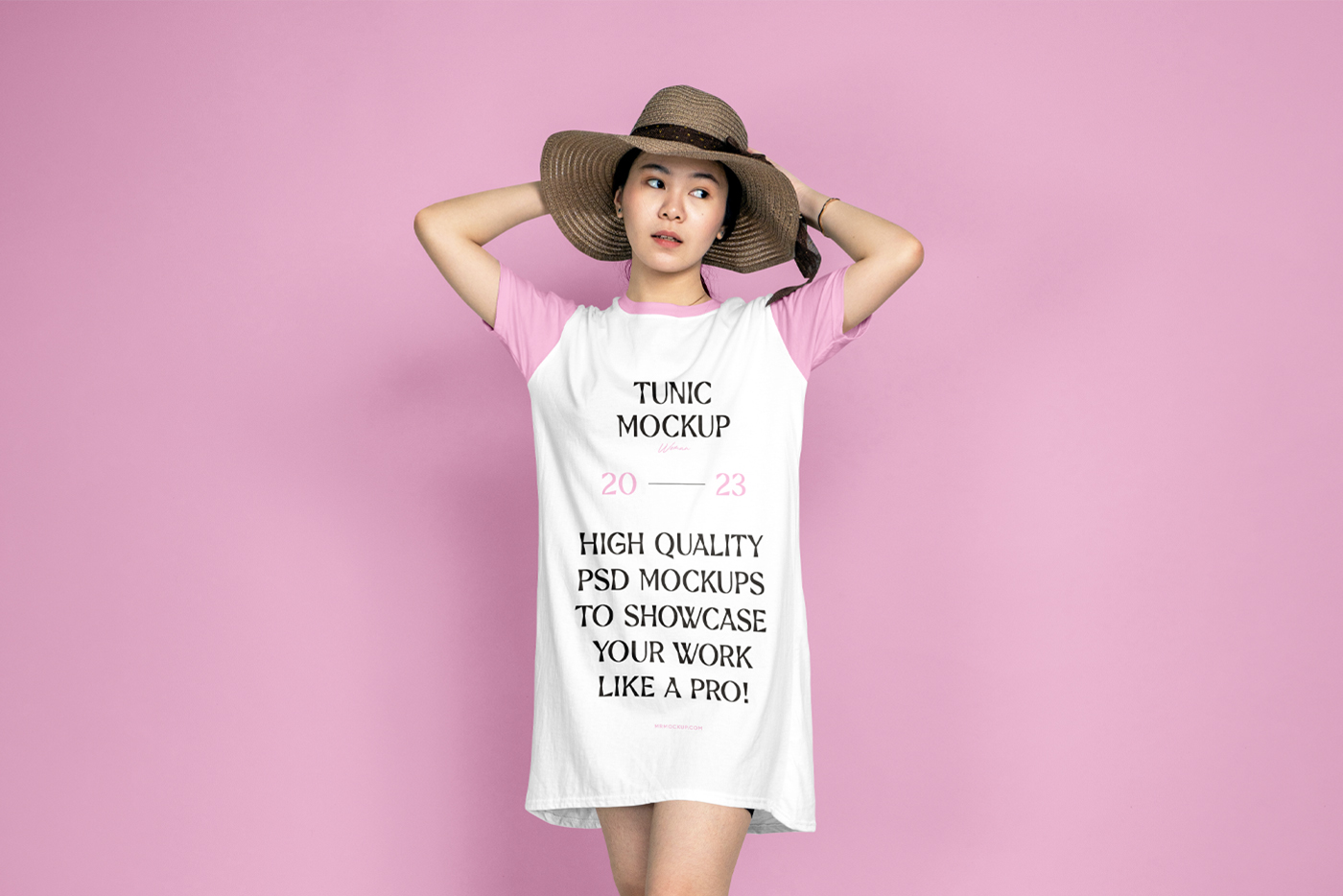 A woman wearing a tunic mockup in front of the pink wall.