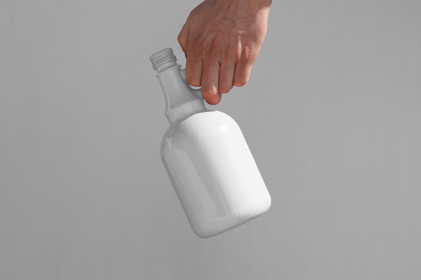Men holding a white ceramic bottle mockup in front of the white wall.