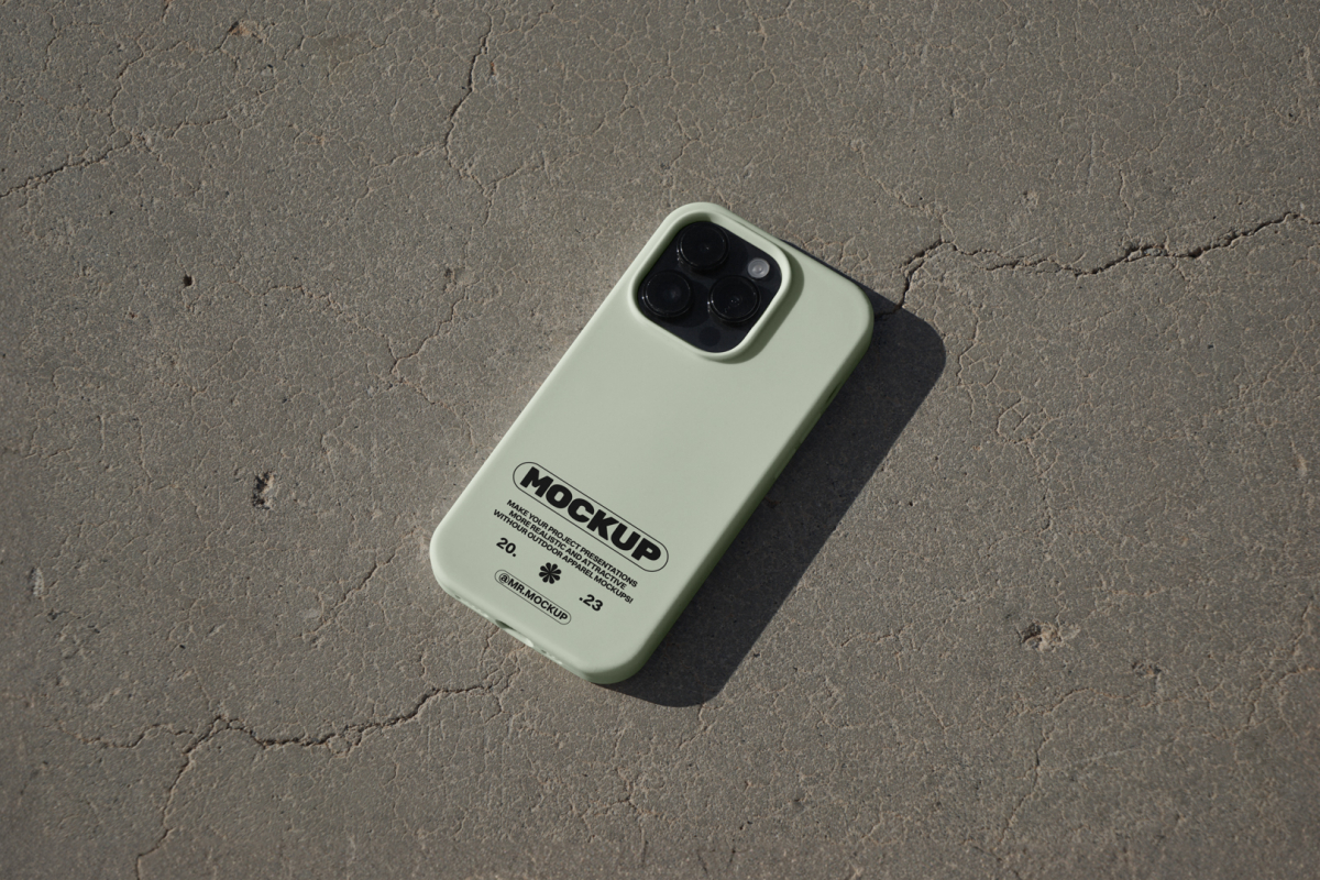 iPhone pro with green case laying on concrete floor.