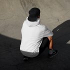 Man with black cap and hoodie on concrete skatepark from outdoor apparel mockups vol.2.