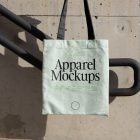 Green canvas bag with black handle hanging in front of handrail.