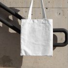 Canvas bag hanging in front of handrail from outdoor apparel mockups vol.2.