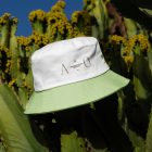 Bucket hat with embroidery design laying on the cactus.