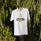 White t-shirt with brown typographic design hanging on the cactus.