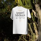 White t-shirt with black and yellow typographic design hanging in front of big cactus.