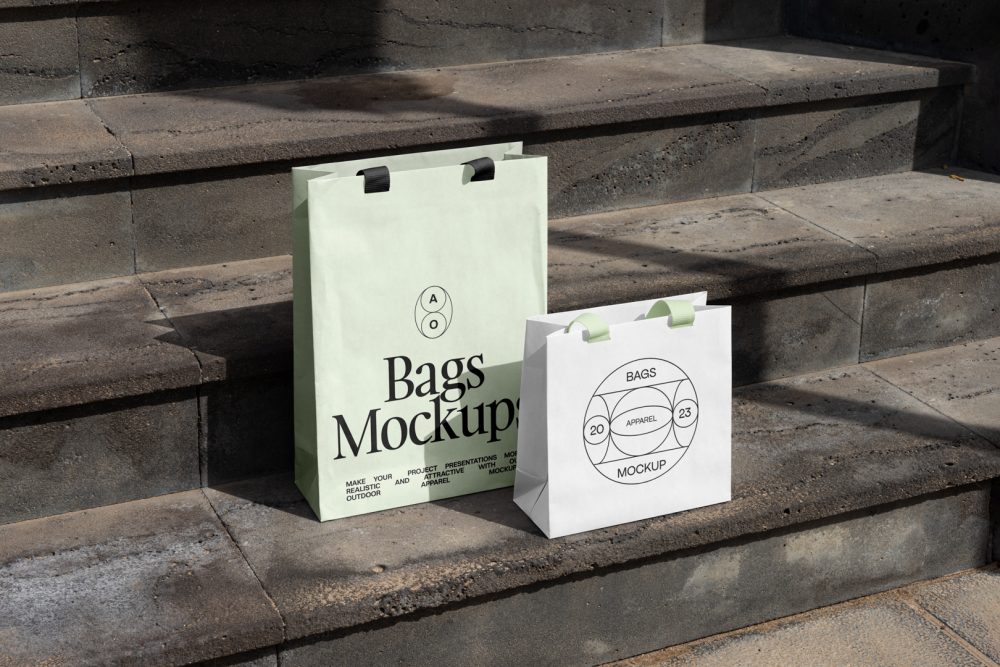 Two paper bags with typographic design on the big concrete stairs.