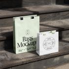 Two paper bags with typographic design on the big concrete stairs.